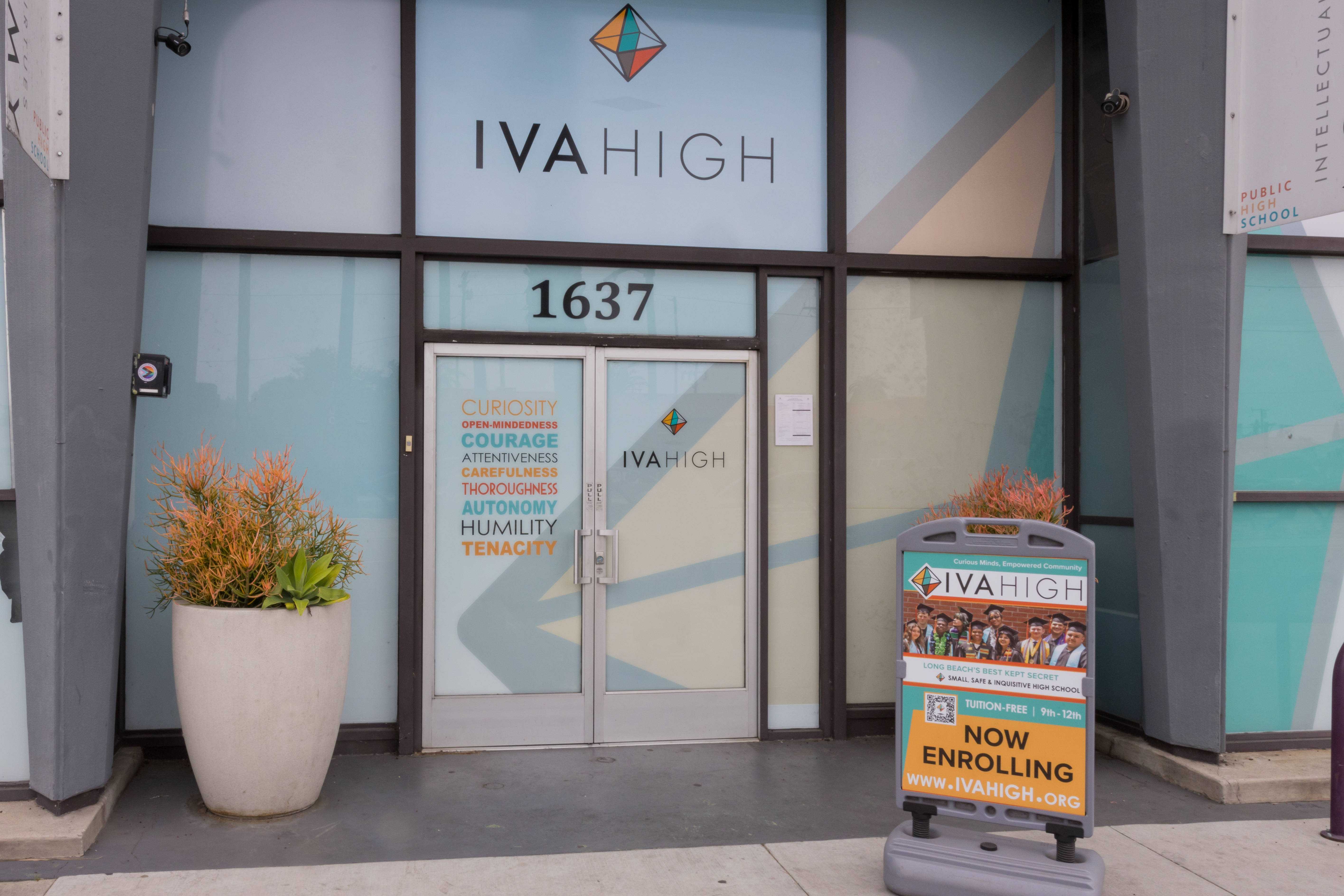 he front entrance of IVA High is brightly colored and a door sign lists the intellectual virtues