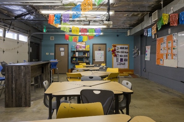 IVA High classroom with tables and chairs and colorful banners across the ceiling