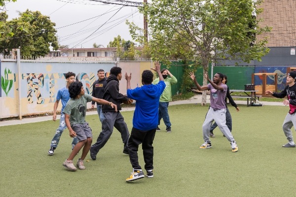 9 IVA students playing basketball in backyard