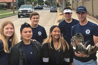IVA High students pose with a cat for a photo during an internship with Animal Rescue.