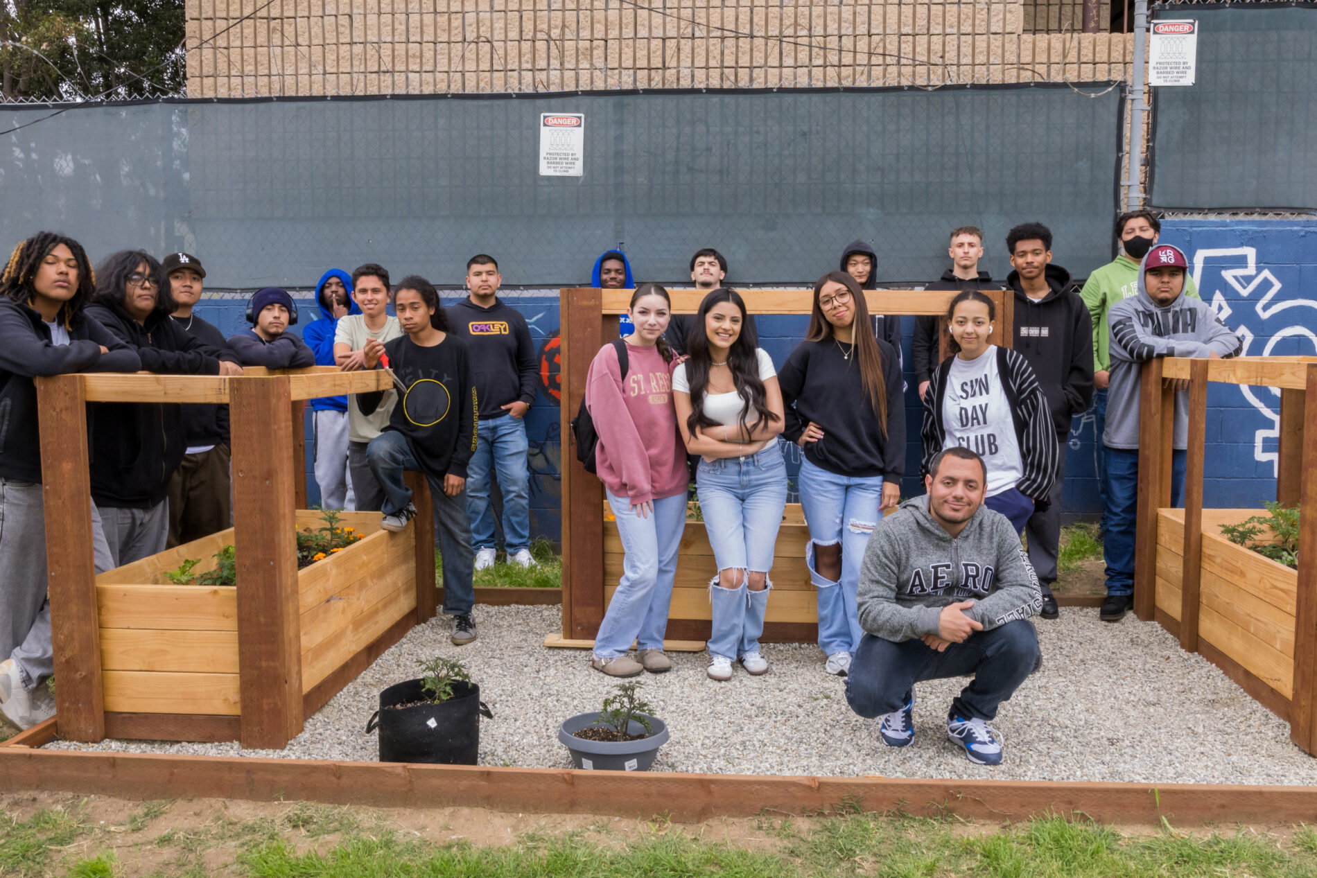 Students at IVA High pose for a group photo in front of garden beds at the school.