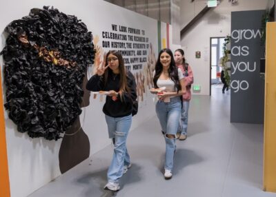 Three students at IVA High in Long Beach walk down a hallway
