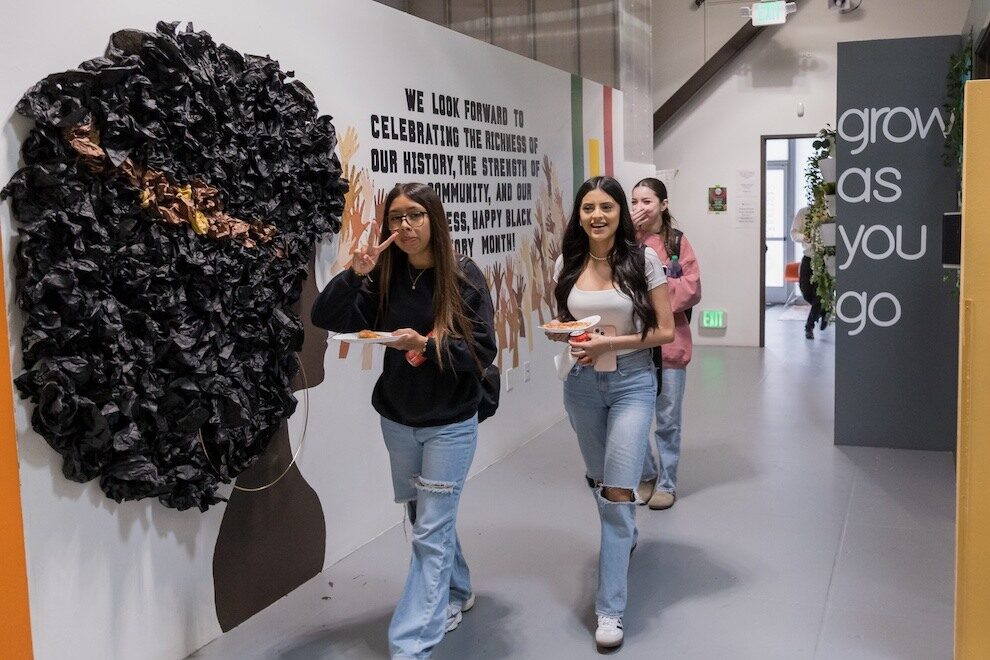 Three students at IVA High in Long Beach walk down a hallway