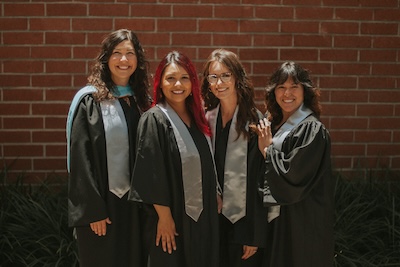 4 IVA High Counselors stand together in graduation regalia