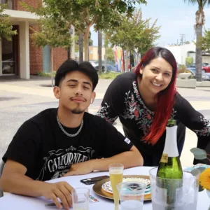 Two people in black shirts at an outdoor dining table