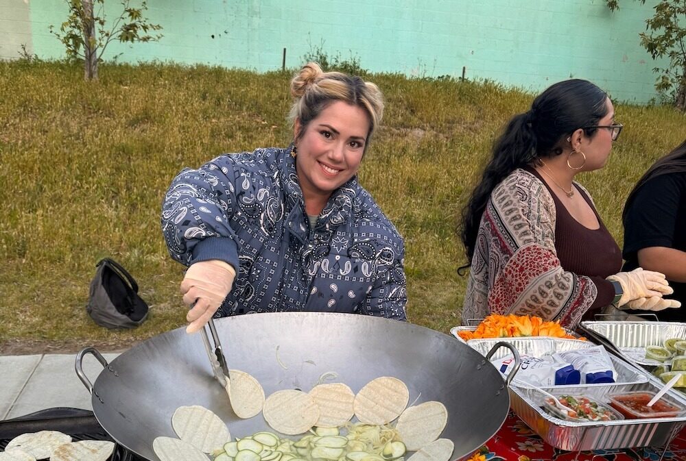 IVA High teacher, Ollie Cigliano, cooks at a large outdoor wok.