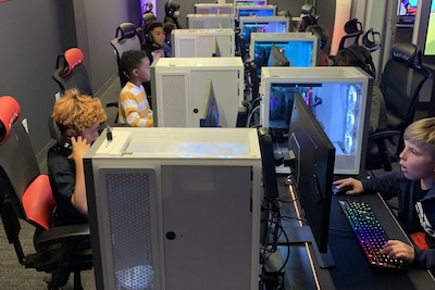Students sit in front of computers in a computer lab.
