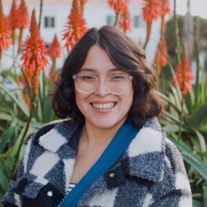 marisol IMG_9159 School Counselor Marisol Marquez stands in front of flowers