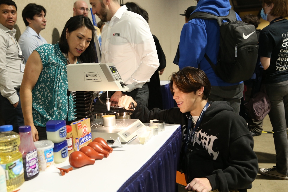 A student from IVA High operates a machine.