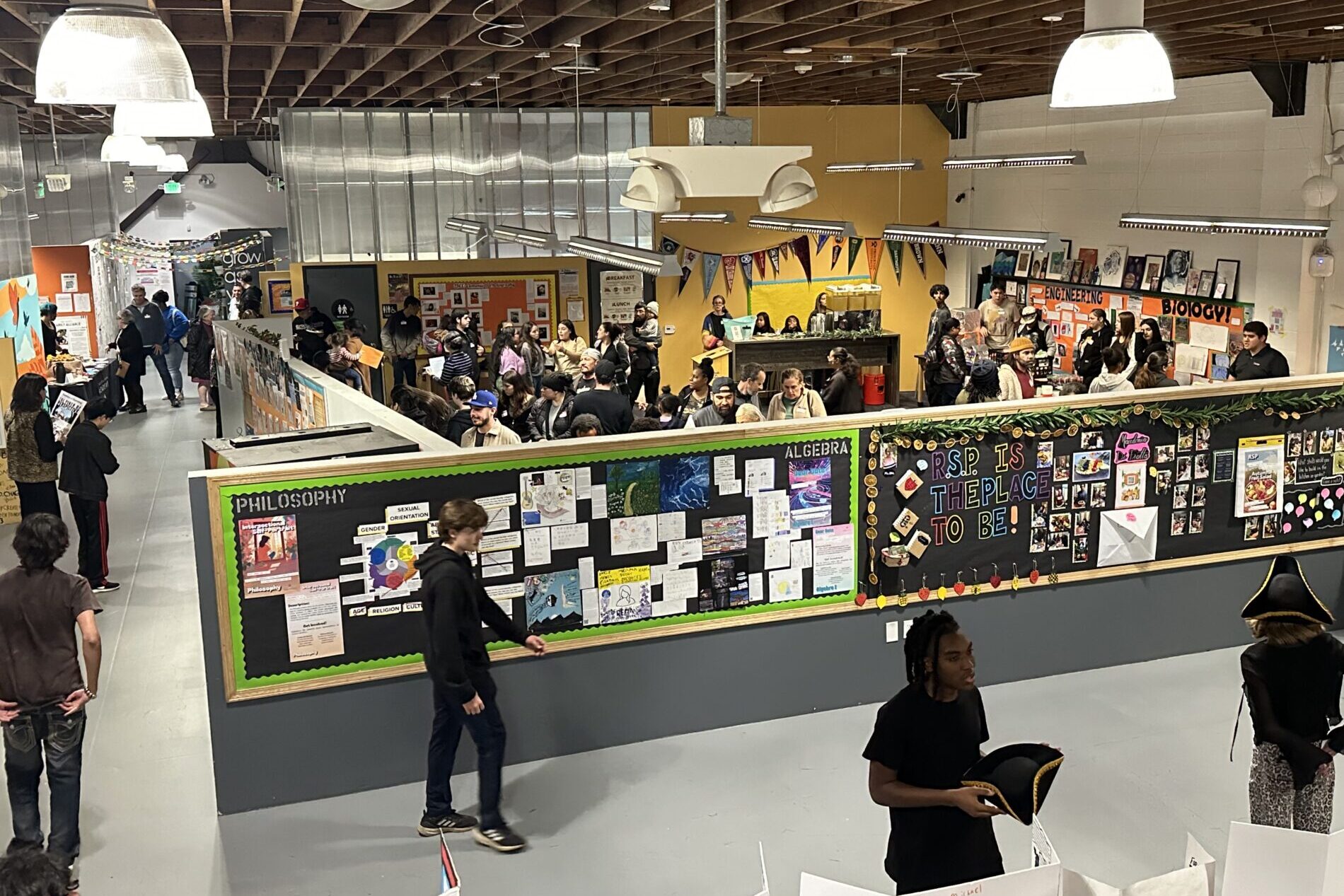 Aerial view of IVA High during an Exhibition of Learning. People are walking around looking at student presentations.