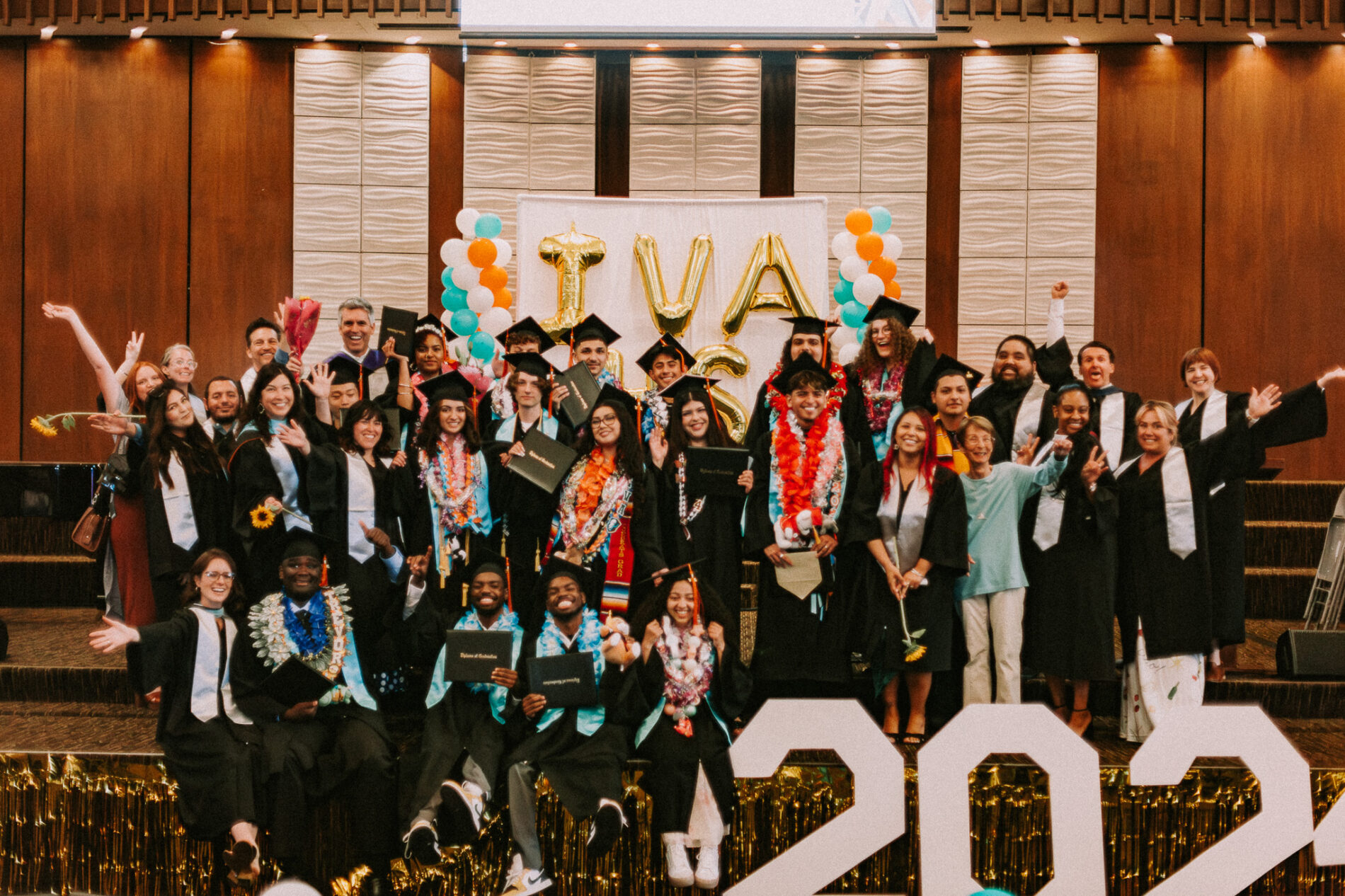 The senior class of IVA High in Long Beach 2026 gathers for a photo wearing their caps and graduation gowns