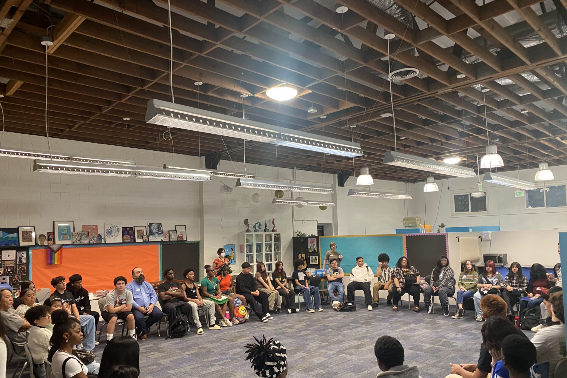 A large open room at IVA High in Long Beach with students sitting in a circle.