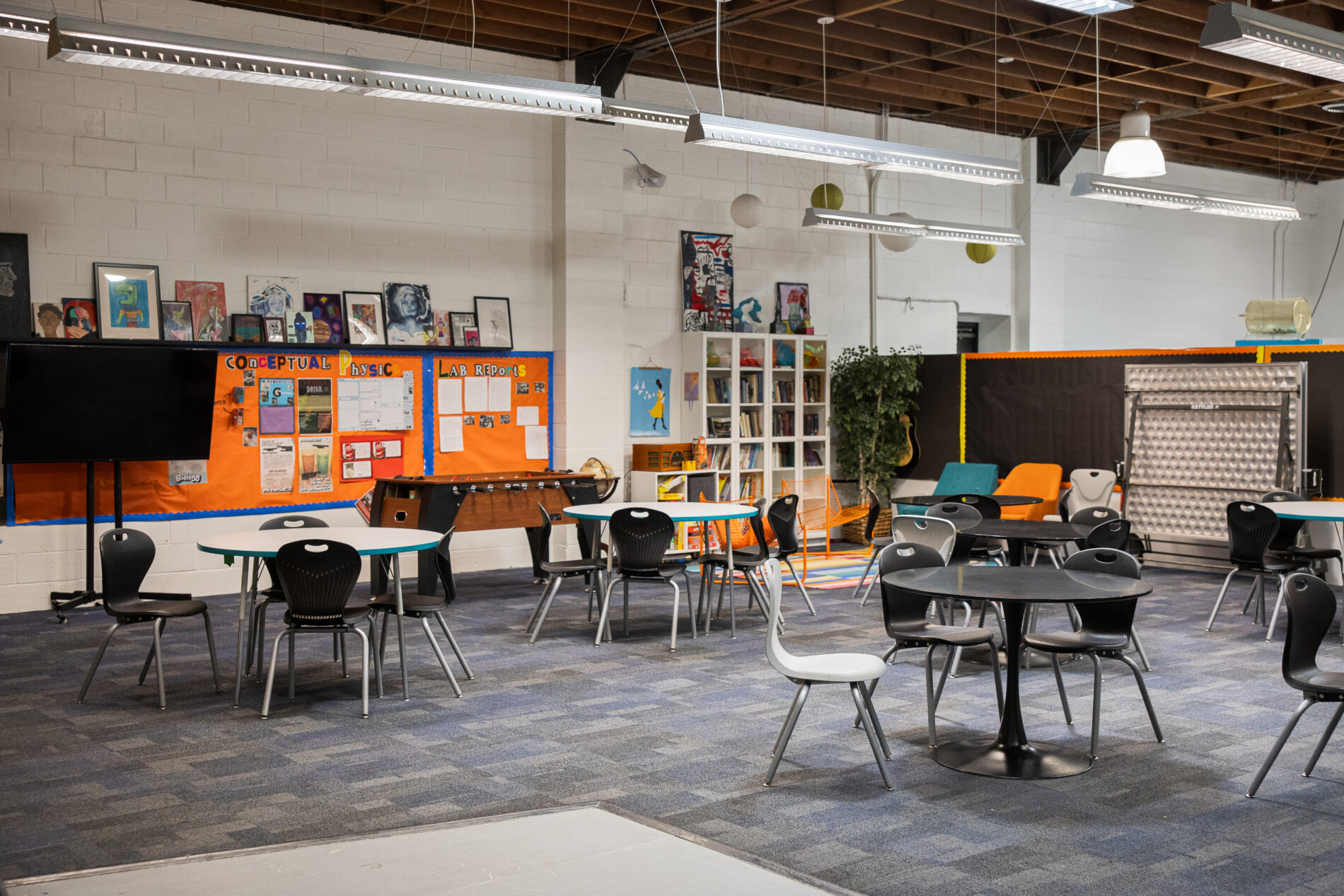 an open room with tables and chairs and bulletin boards at IVA high in Long Beach